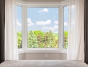 bay window in living room of home with white curtains after getting cost estimate from professional contractor