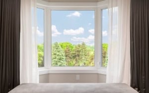 bay window in living room of home with white curtains after getting cost estimate from professional contractor